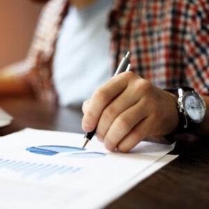 A man making notes on a paper with a diagram.